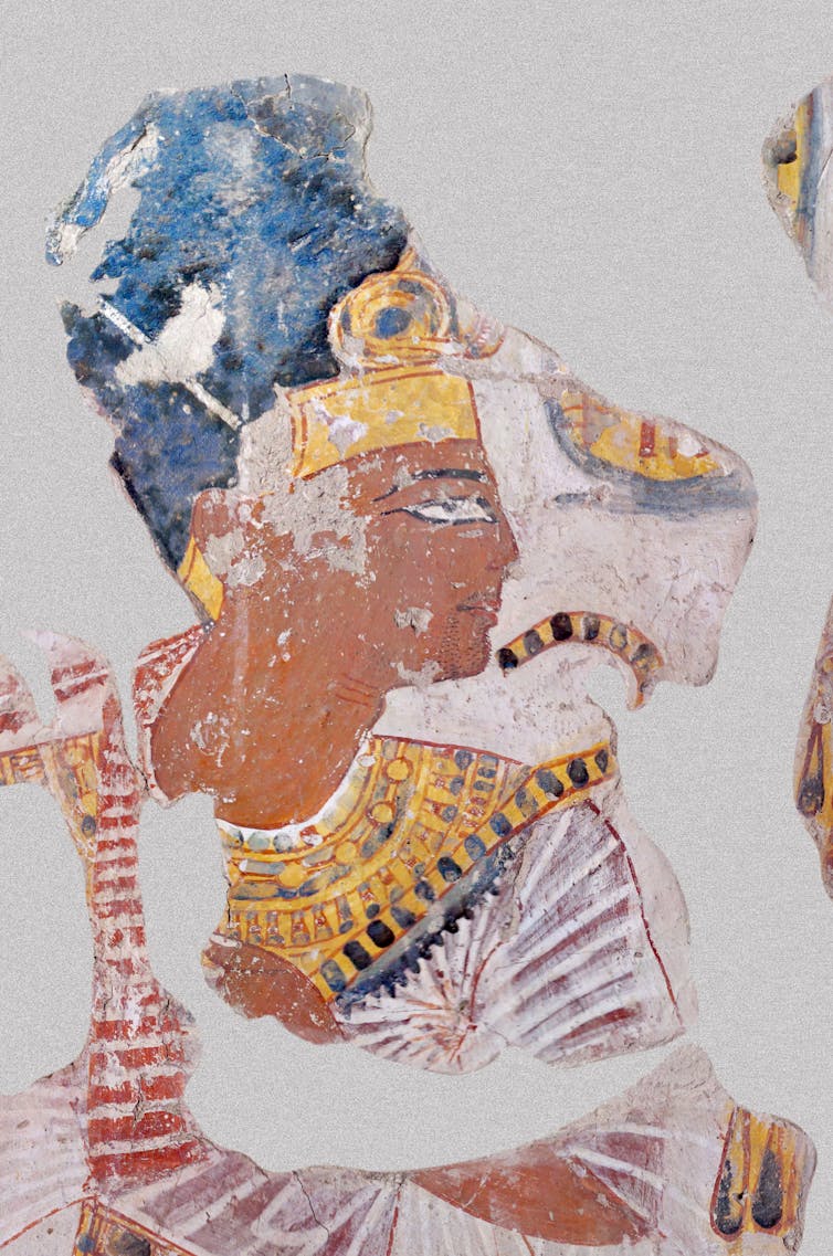 An Egyptian tomb portrait of a Pharoah dressed in blue and gold.