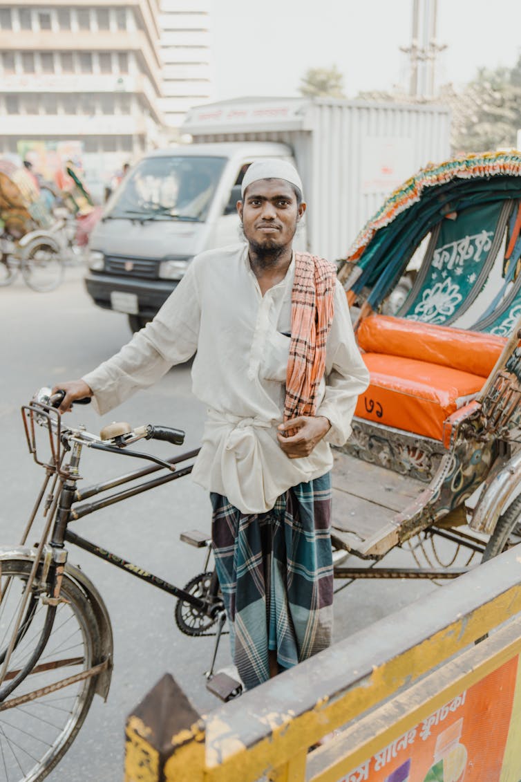 A cycle-rickshaw driver on a Dhaka class=