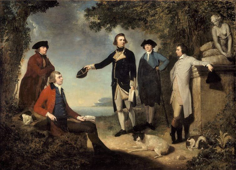 A painting showing five men, two dogs, and a statue of a woman standing in a clearing near the ocean shore. The center man, James Cook, is holding his hat out.