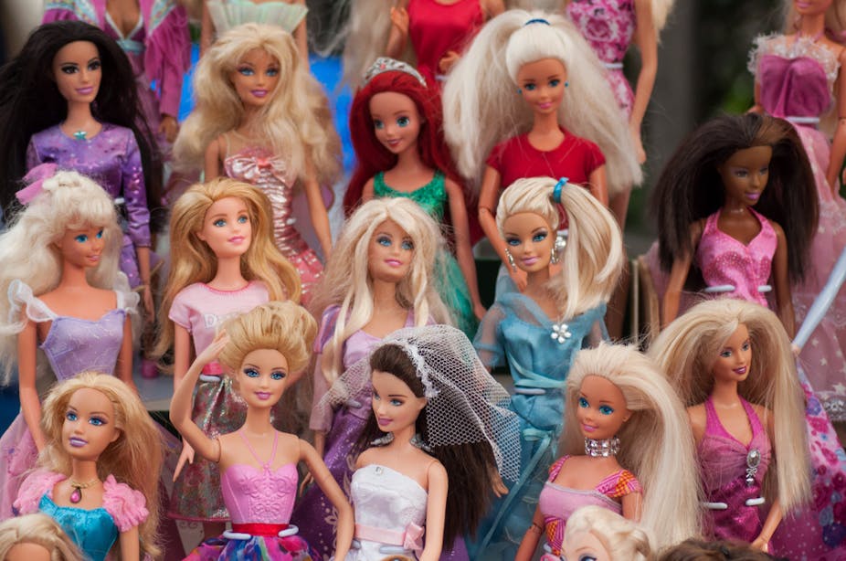 Gros plan sur une collection de poupées Barbie dans une brocante
