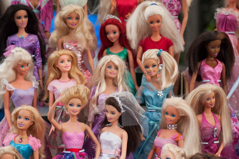 Gros plan sur une collection de poupées Barbie dans une brocante