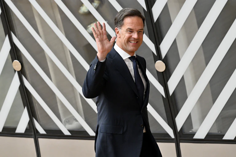Mark Rutte salue des photographes