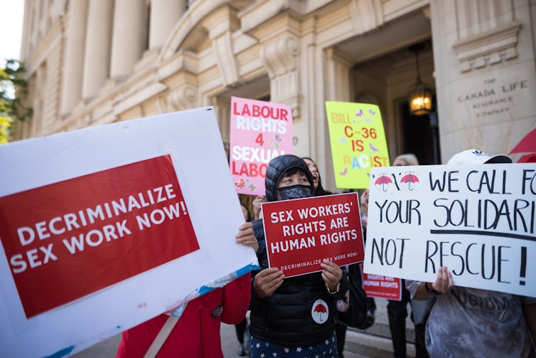 People holding placards protest outside a building