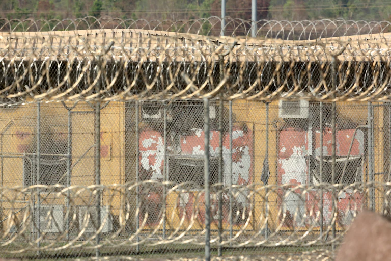 An outside view of Don Dale detention centre. It's a building with large fencing around it with coiled wire on the top.