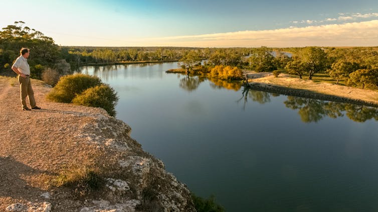 man overlooks river bend