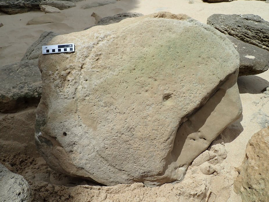 A large, smooth grey rock on which the deep impression of part of a circle can be seen