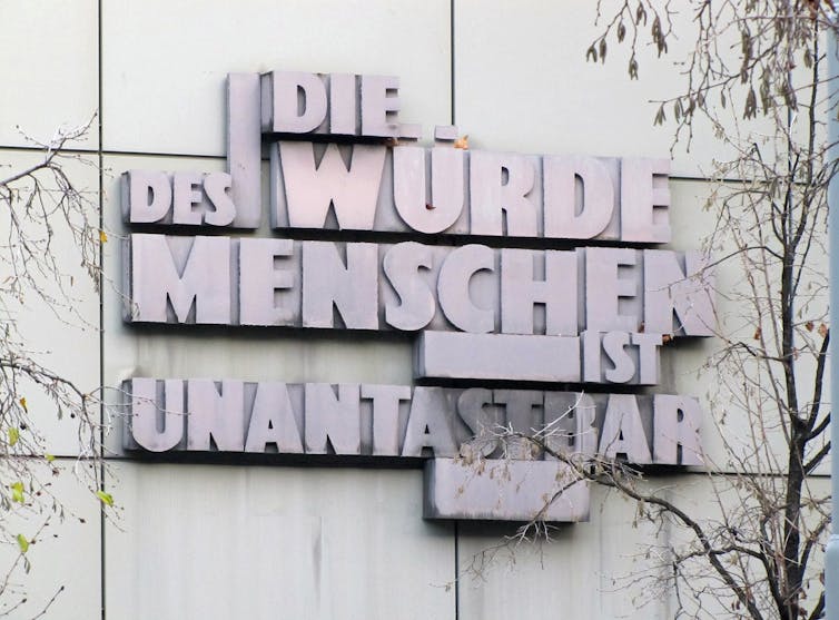 A sculpture of German words on a building.