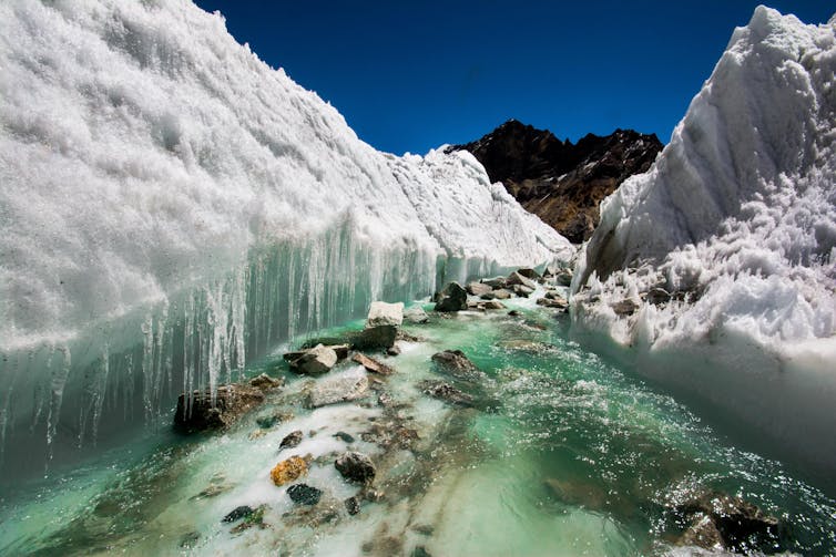 Meltwater carving a glacier in the Himalayas of India.