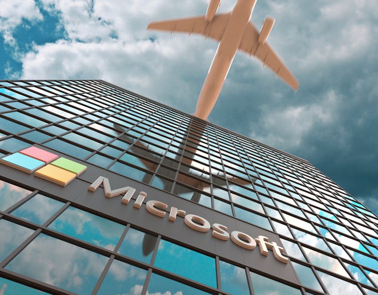 Plane flying over Microsoft office block