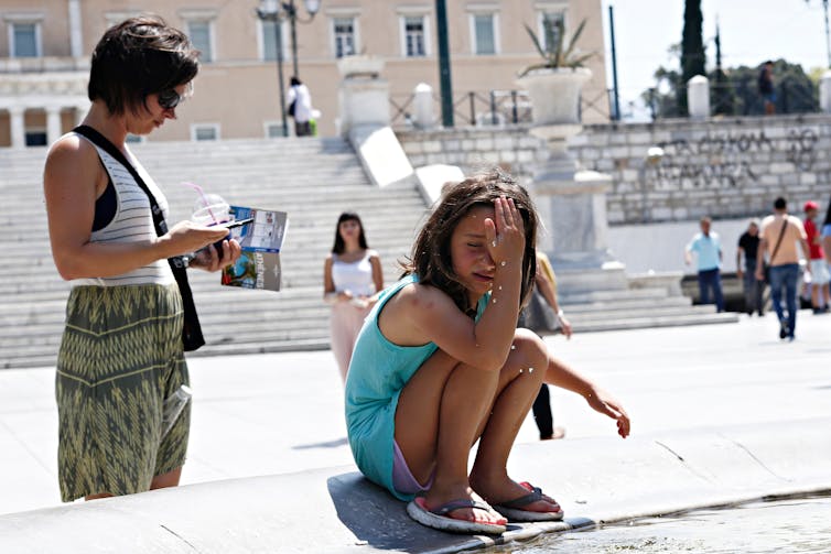 A girl cools off in fountain during a heatwave in Athens, Greece.