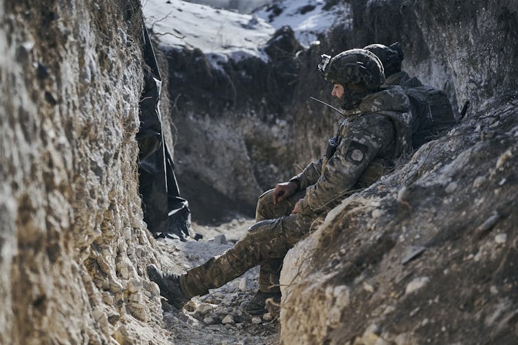 Soldiers in battle fatigues in a trench.