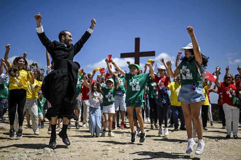 Un prêtre en soutane dans avec un groupe de jeunes gens