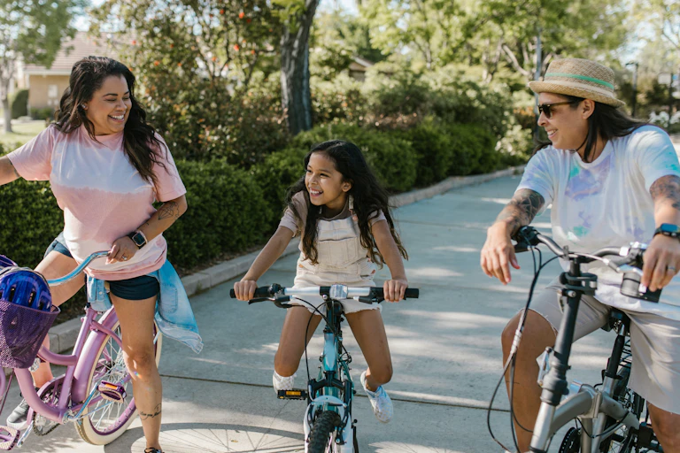 Parents and child outside with bikes.