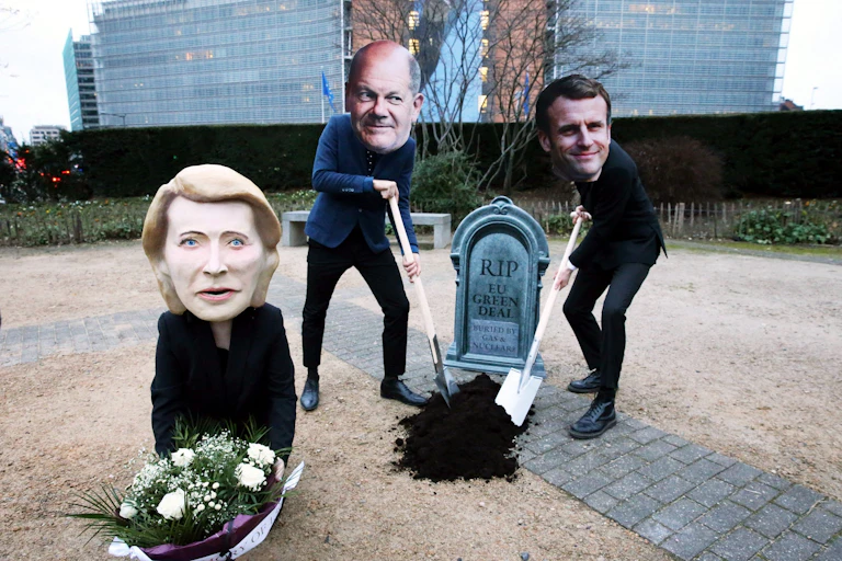 Demonstrators wear masks of European politicians during a demonstration in 2022