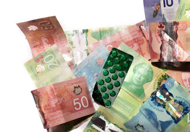 stock photo of Canadian currency with a pack of the pills in green plastic packaging