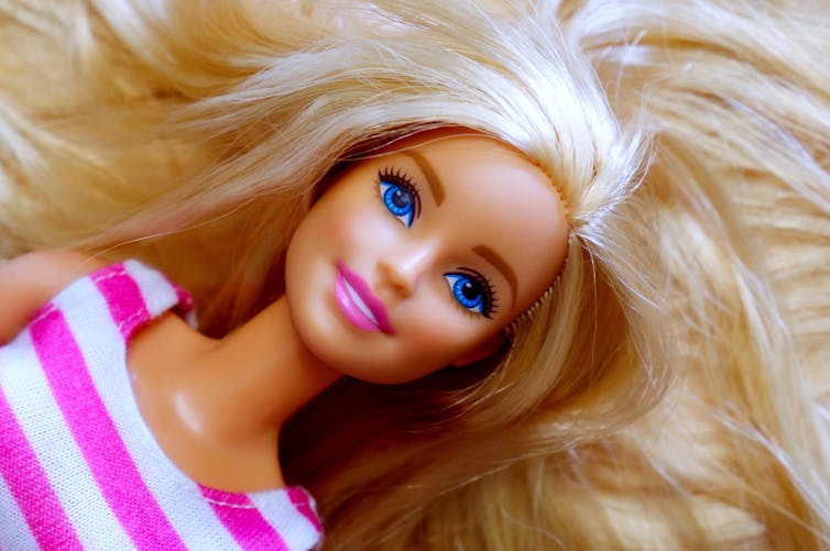 Close up photo of a blonde, white Barbie doll's head and hair.