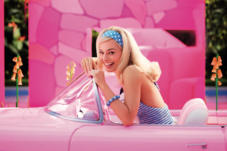 Barbie sat in a pink convertible car.