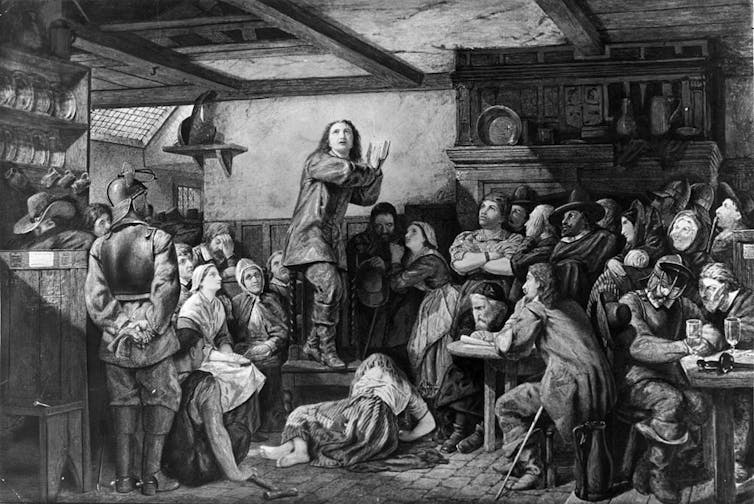 A black and white drawing inside a pub shows a man in early modern dress standing on a bench and speaking as if in a trance.