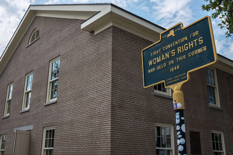 A brick two-story building with a New York State historic marker in the front.