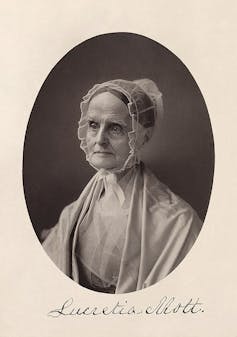 A formal, black-and-white photo of an older woman wearing a gauzy bonnet and shawl.