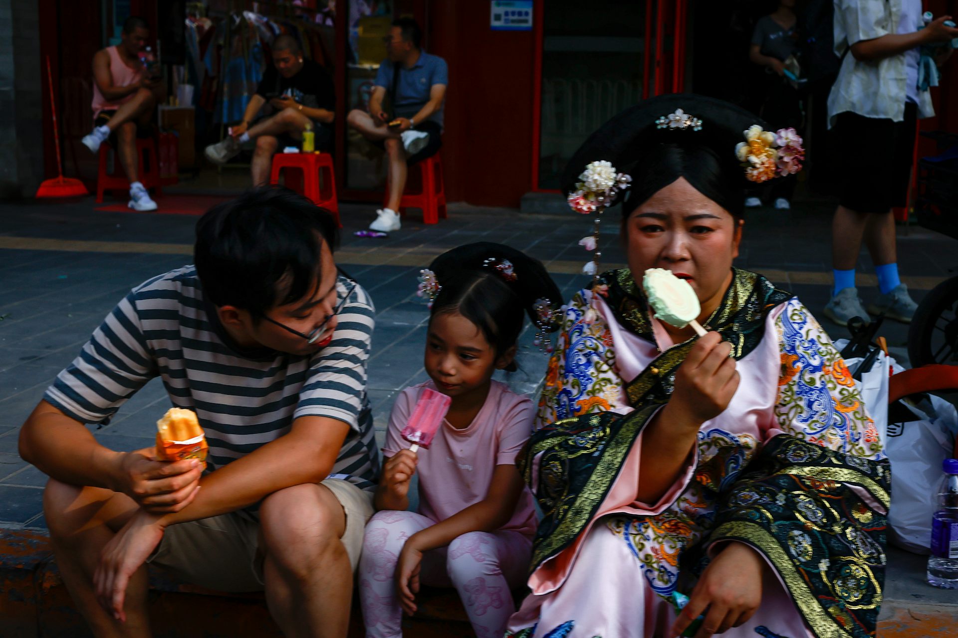 two adults and a child eat ice creams