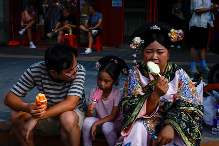 two adults and a child eat ice creams