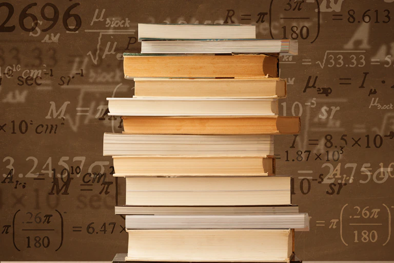 A stack of books sits on a table with math formulas in the background.