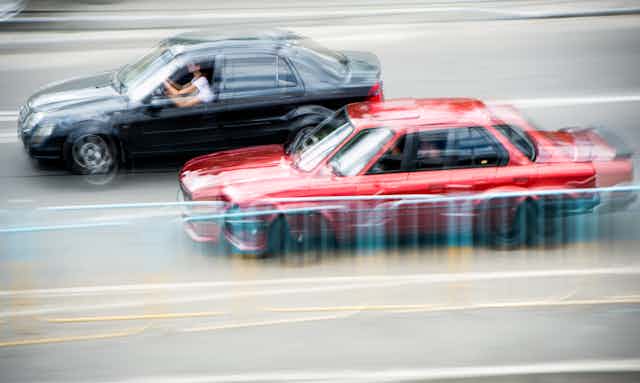 Blurred cars driving past each other.