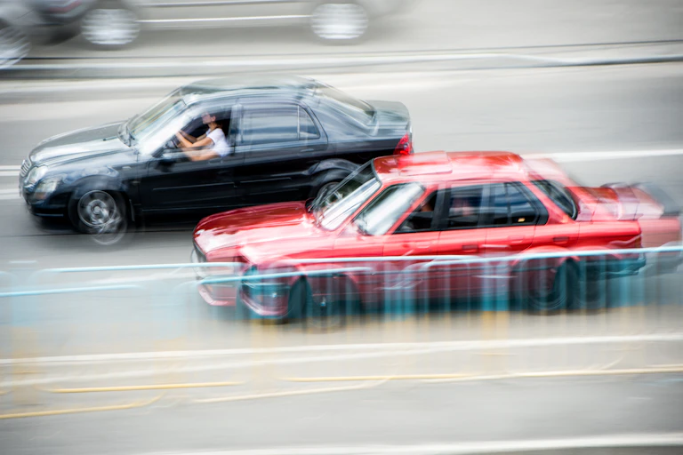 Blurred cars driving past each other.