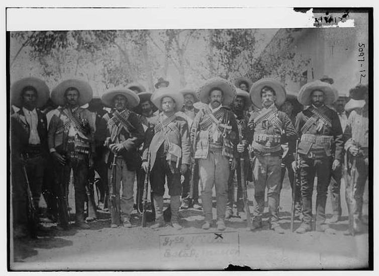 Pancho Villa en el centro rodeado de soldados vestidos como él.