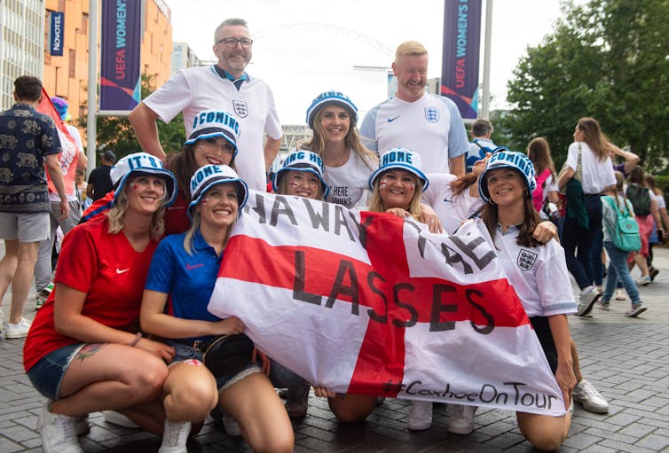 England women's fans holding an England flag and wearing matching bucket hats.
