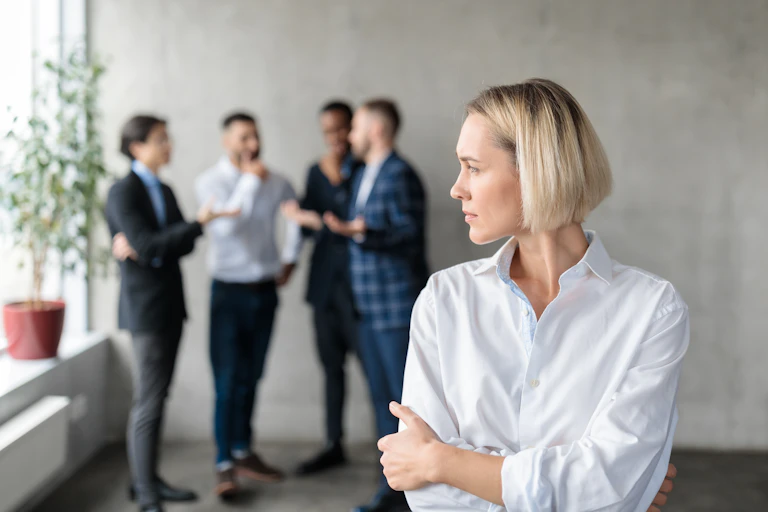 Une femme, les bras croisés, se tient devant un groupe d'hommes