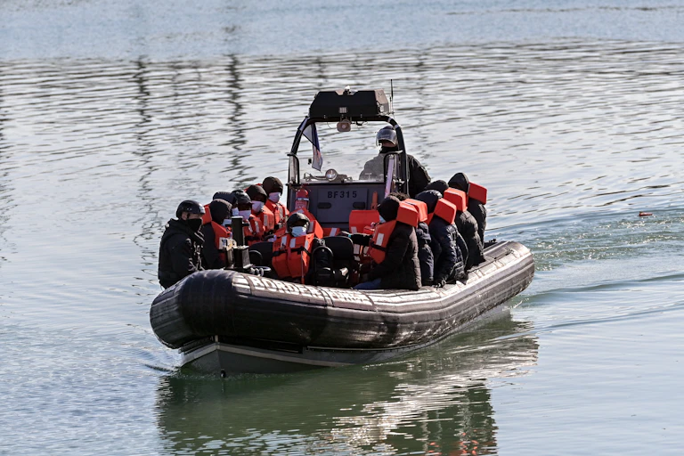 A small border force boat carrying migrants in life jackets