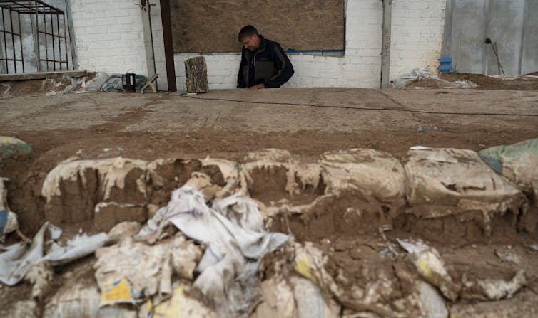 A man behind bags of sand.