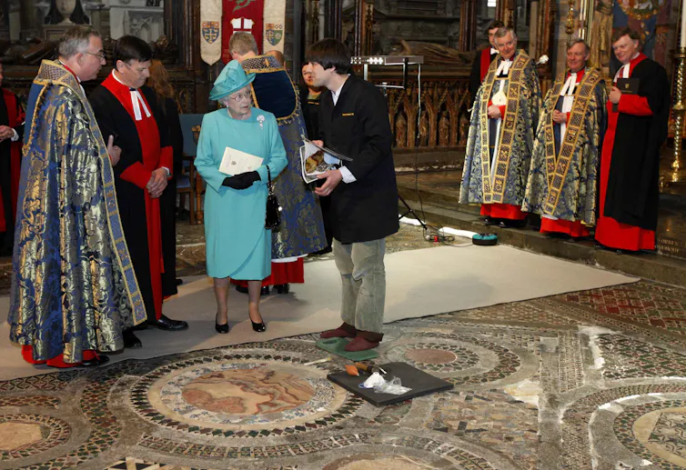 The Queen stands in Westminster Abbey with a conservator.
