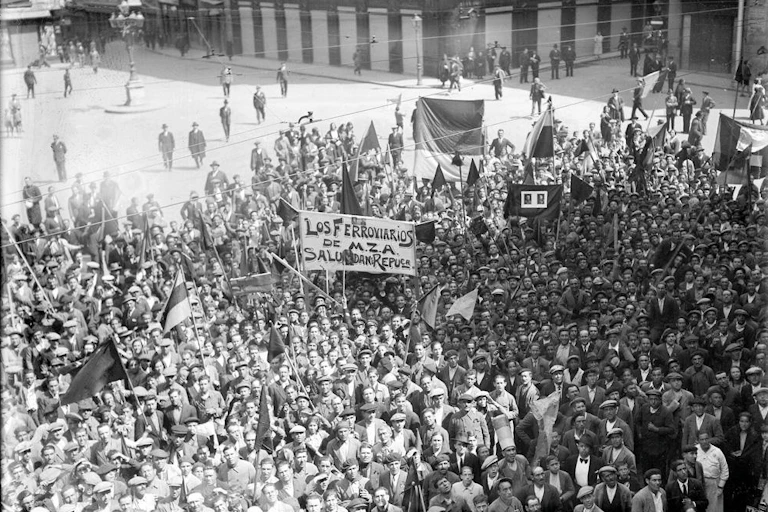 Black and white photograph of a crowd with banners and Spanish Republican flags,