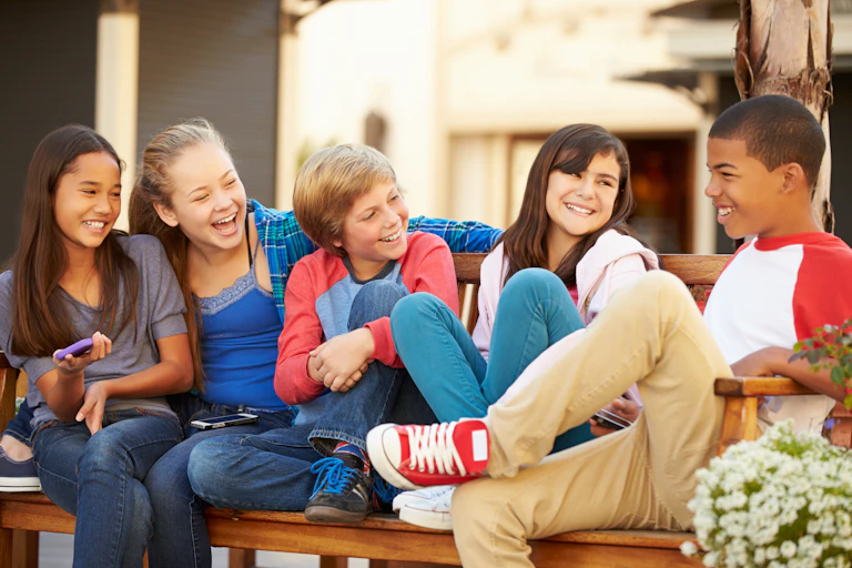 Five children hanging out on a bench.