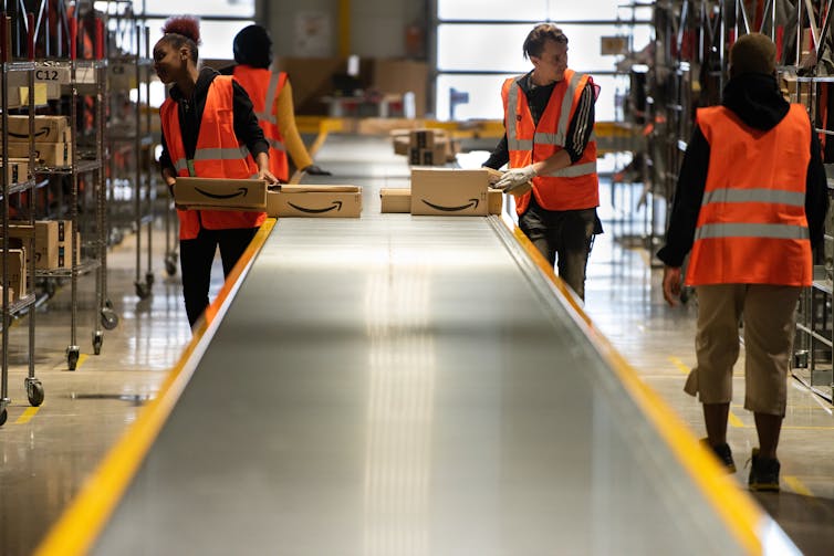 Des ouvriers Amazon du centre de logistique de Velizy trient des colis