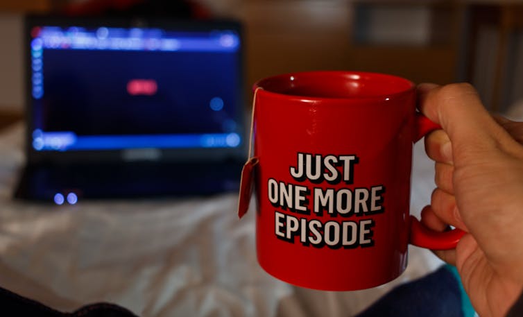 Hand holding red mug that says 