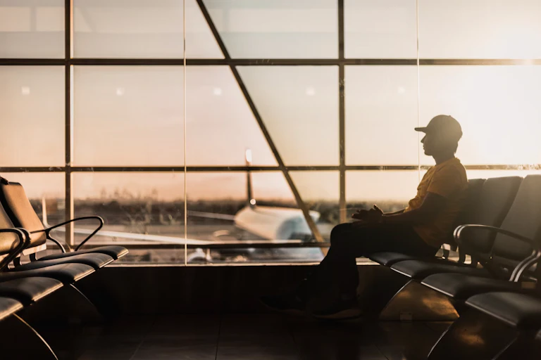 homme assis dans une salle d'embarquement