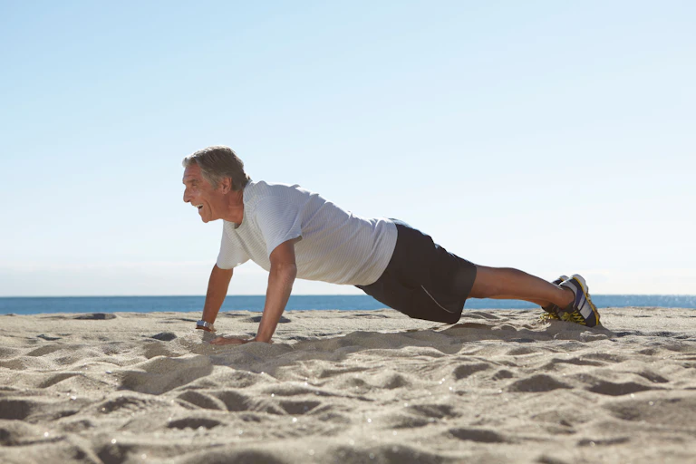 Man doing pressups on a beach