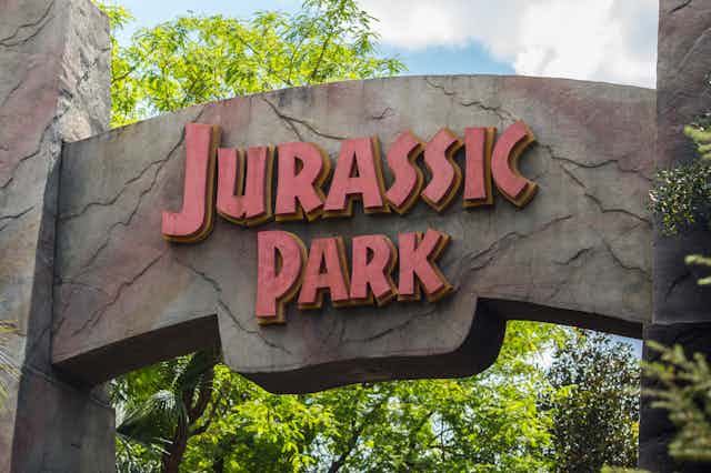 gate sign on an arch that says Jurassic Park