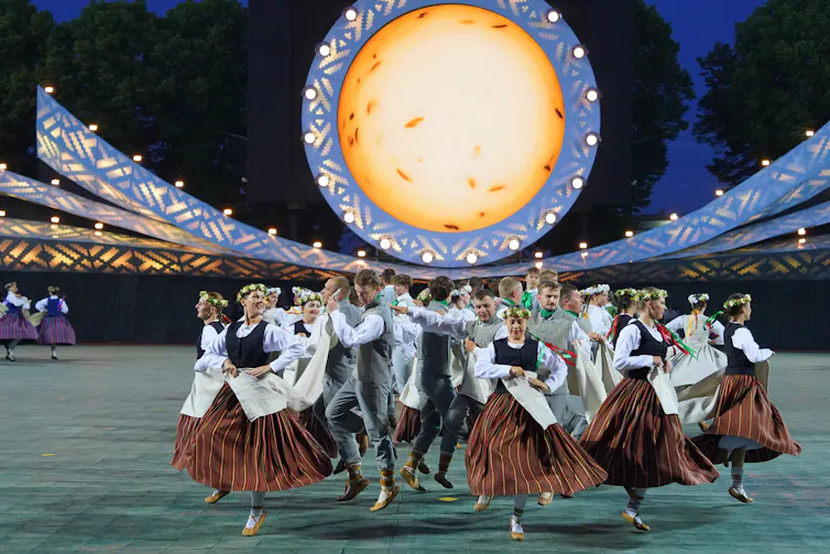 People dancing under a yellow orb