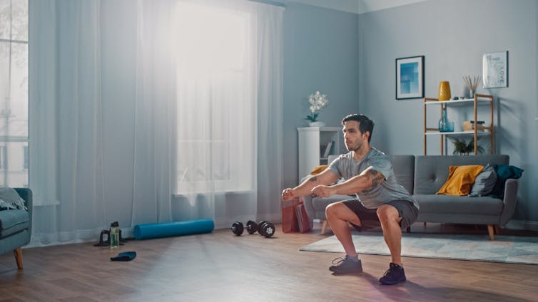 Man does a squat in his living room