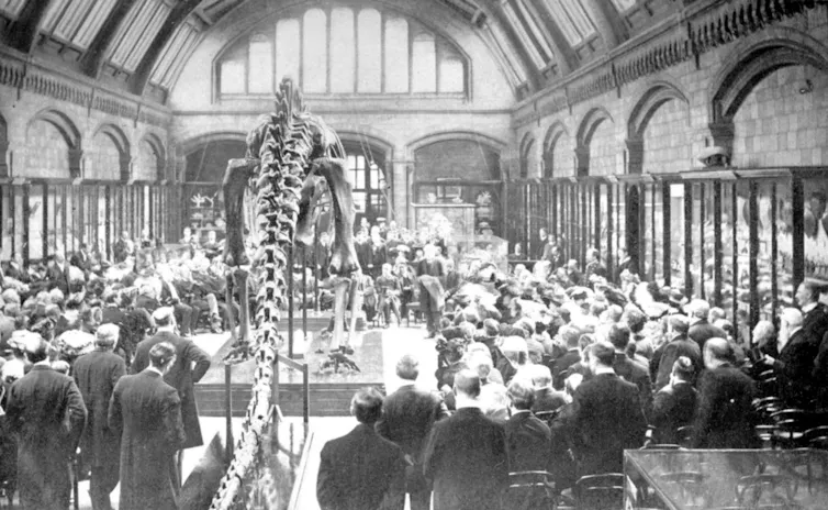 Dippy surrounded by scientists in a black and white photo.