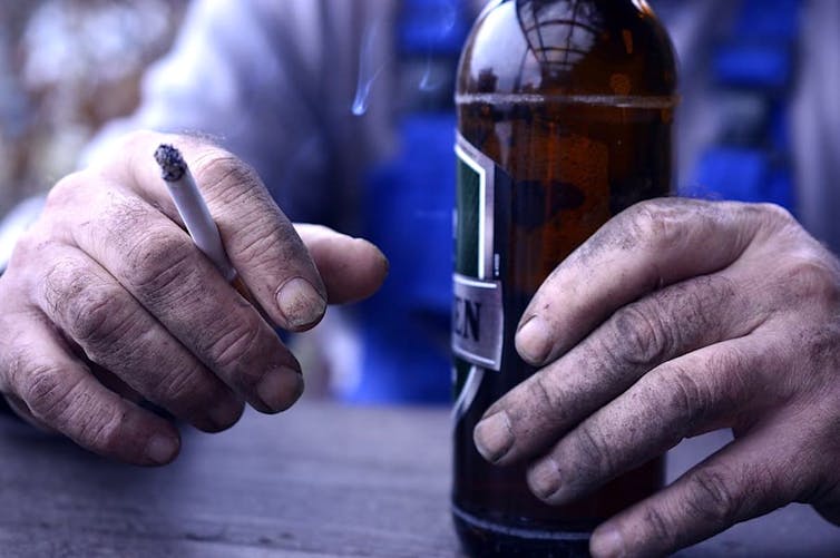 Ouvrier buvant une bière et fumant une cigarette