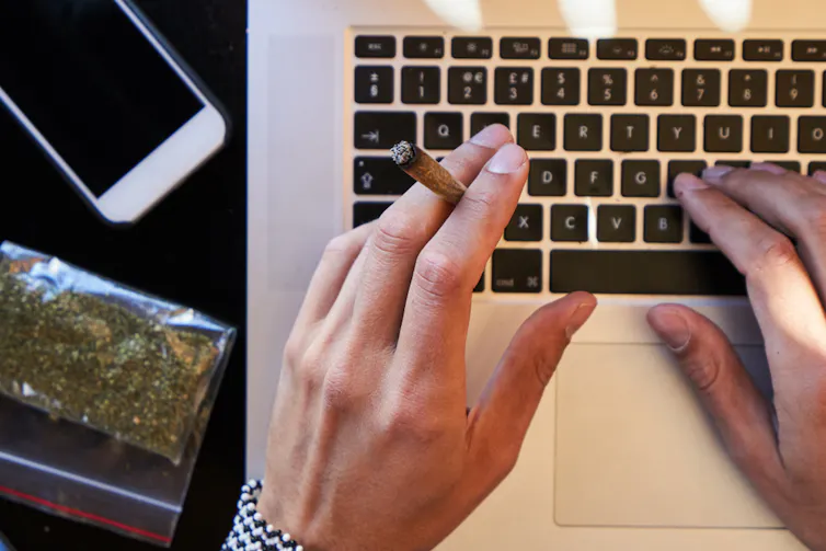 Homme consommant du cannabis devant son écran d’ordinateur