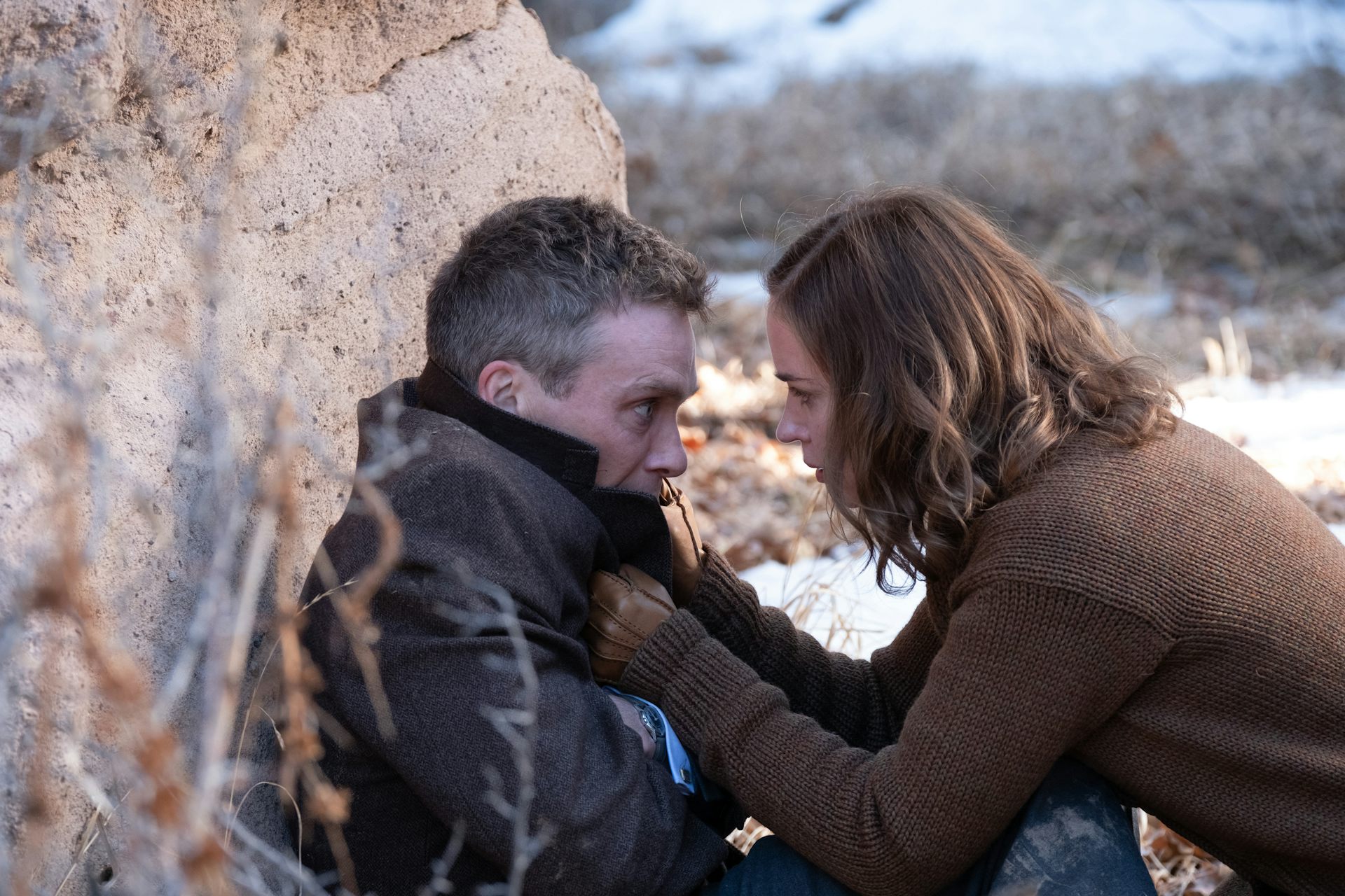 Emily Blunt grabbing Cillian Murphy's jacket collar.