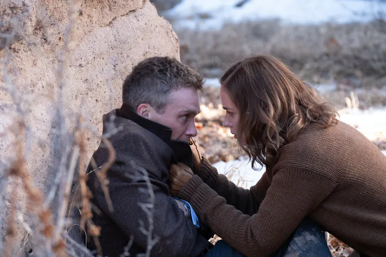 Emily Blunt grabbing Cillian Murphy's jacket collar.