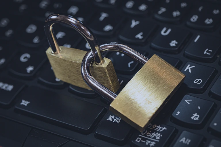 Two locked padlocks on a computer keyboard